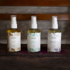 Three bottles of 'Hope Unite' products labeled 'Joy', 'Love', and 'Peace' on a wooden surface.